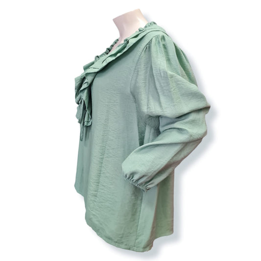 Diese Bluse Eva in der Farbe Mint ist aus 85% Viskose und 15% Nylon gefertigt. Sie besticht durch ihren weiten Schnitt und die zarten Rüschen. Genießen Sie den angenehmen Tragekomfort und die luftige Leichtigkeit - perfekt für einen stilvollen Look. Seitenansicht.