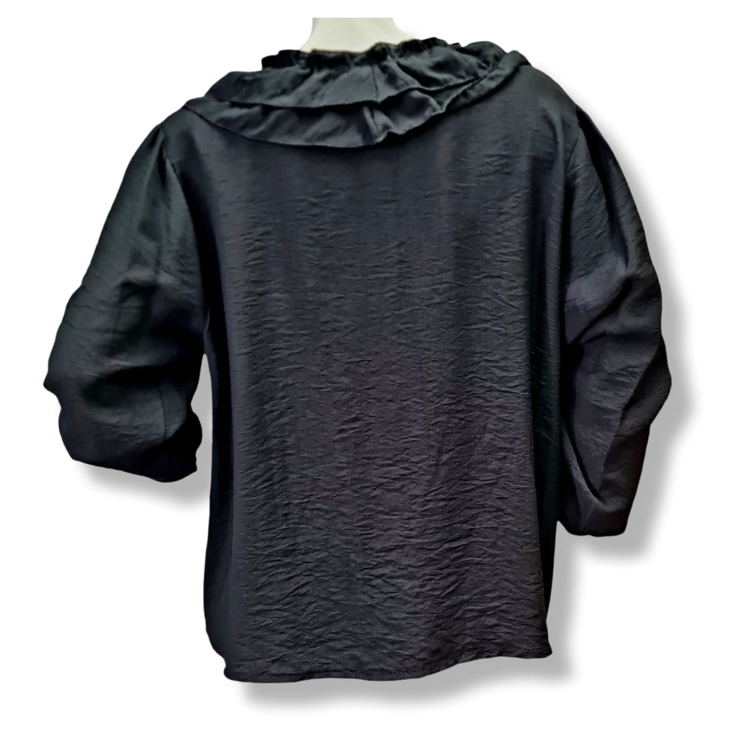 Die Bluse Eva besteht aus 85% Viskose und 15% Nylon und hat einen weiten Schnitt mit Rüschen. Sie bietet einen klassischen Look in zeitlosem Schwarz. Perfekt für jeden Anlass und angenehm zu tragen dank hochwertiger Materialien. Rückenansicht.