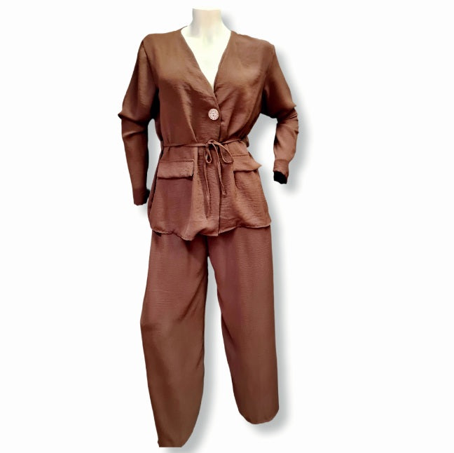 Bluse mit Bindegürtel und einen Goldenen knopf auch als Jacke tragbar. mit aufgesetzten Blindtaschen. Lang Ärmeln. In der Farbe Braun. Hier mit der Palazoo hose aus der selben Farben und Material.