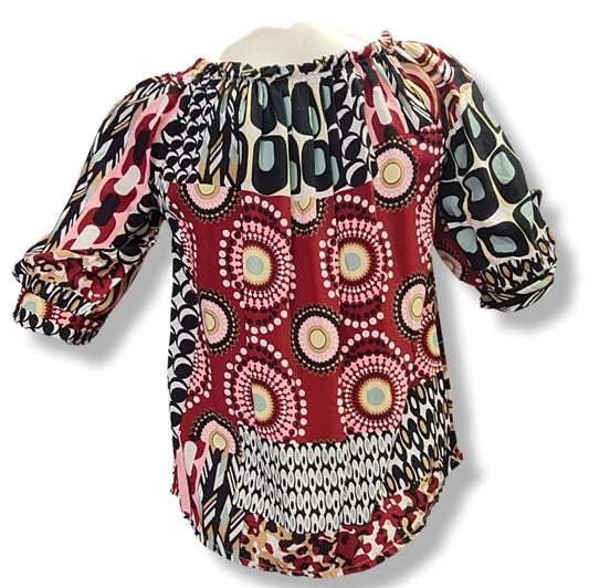 Eine Bluse mit Carmenausschnitt in den Farben Rosa, Rot mit halbarm und schlupe. Geomuster mit Kreisen.