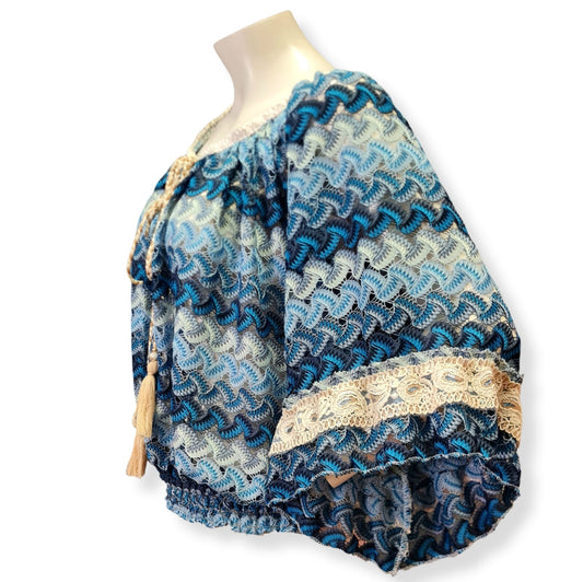 Diese elegante Bluse Roma in der Farbe Blau Beige besteht zu 100% aus Microfaser und hat kurze, weite Trompetenärmel. Die Passform ist sehr elegant und verleiht Ihnen einen professionellen Look. Perfekt für den täglichen Gebrauch oder besondere Anlässe. Bestellen Sie noch heute Ihre Bluse Roma. Seitenansicht.