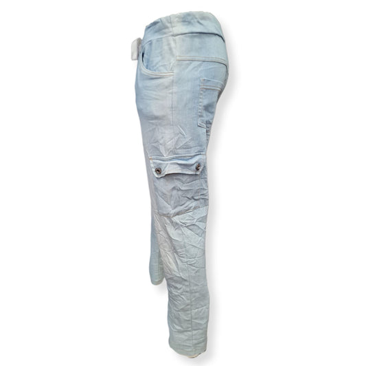 Baumwolle, Elastan und Nylon machen diese Hose nicht nur bequem, sondern auch strapazierfähig. Der breite Gummibund mit Kordel sorgt für einen perfekten Sitz, während die aufgesetzten Taschen am Oberschenkel sportlich und praktisch sind. Zeigen Sie Stil und Komfort in dieser Hose Blanco Jeansblau. Seitenansicht.