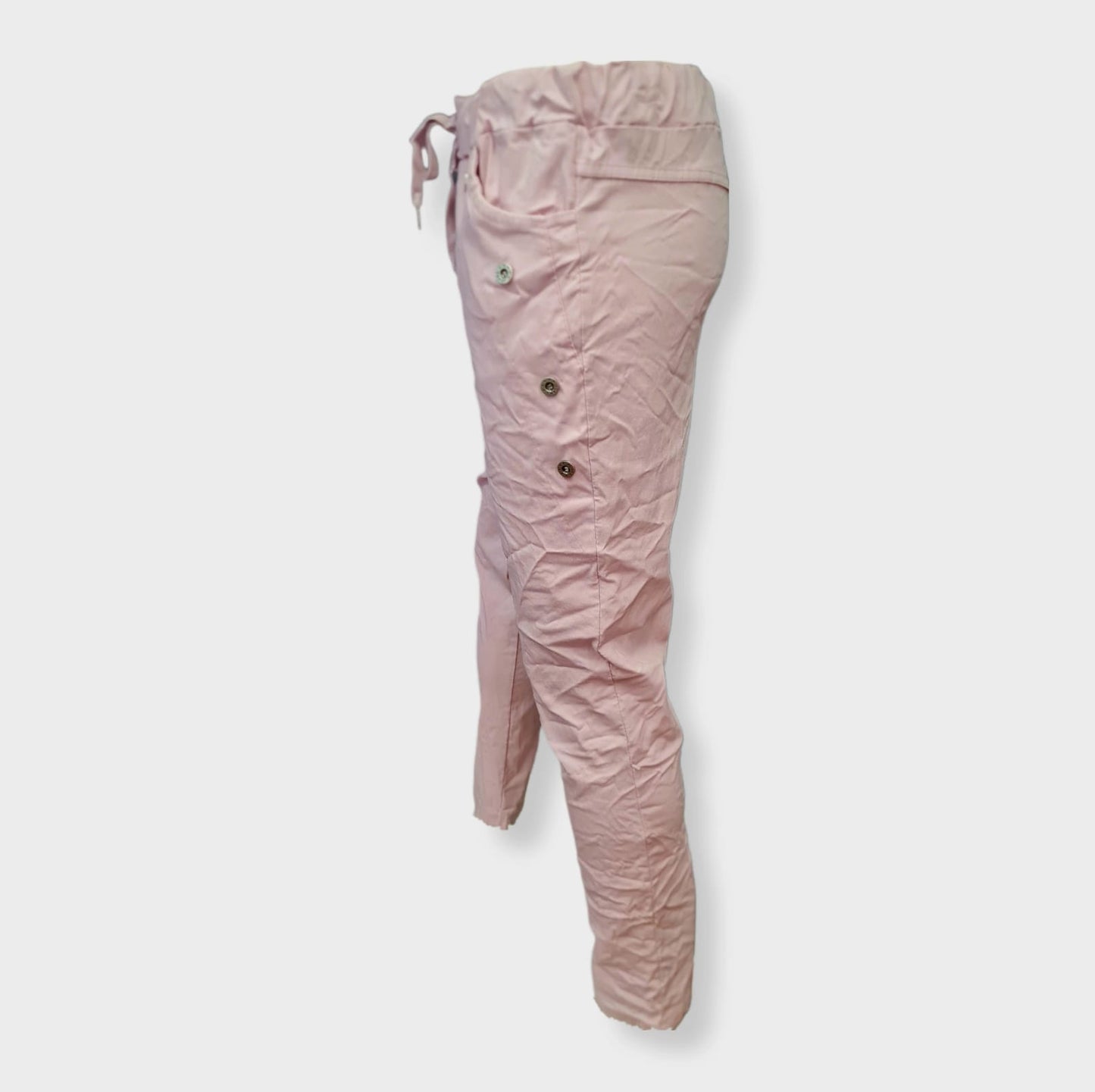 Hose Blanco Rose ist eine sportlich-lässige Hose in der Farbe Rose mit Taschen und verziert mit silbernen Jeansknöpfen. Der breite Gummi Bund mit Kordel sorgt für eine bequeme Passform. Hergestellt aus 76% Viskose, 21% Nylon und 3% Elastan, bietet sie ein angenehmes Tragegefühl. Perfekt für einen lässigen Look mit Stil! Seitenansicht links.