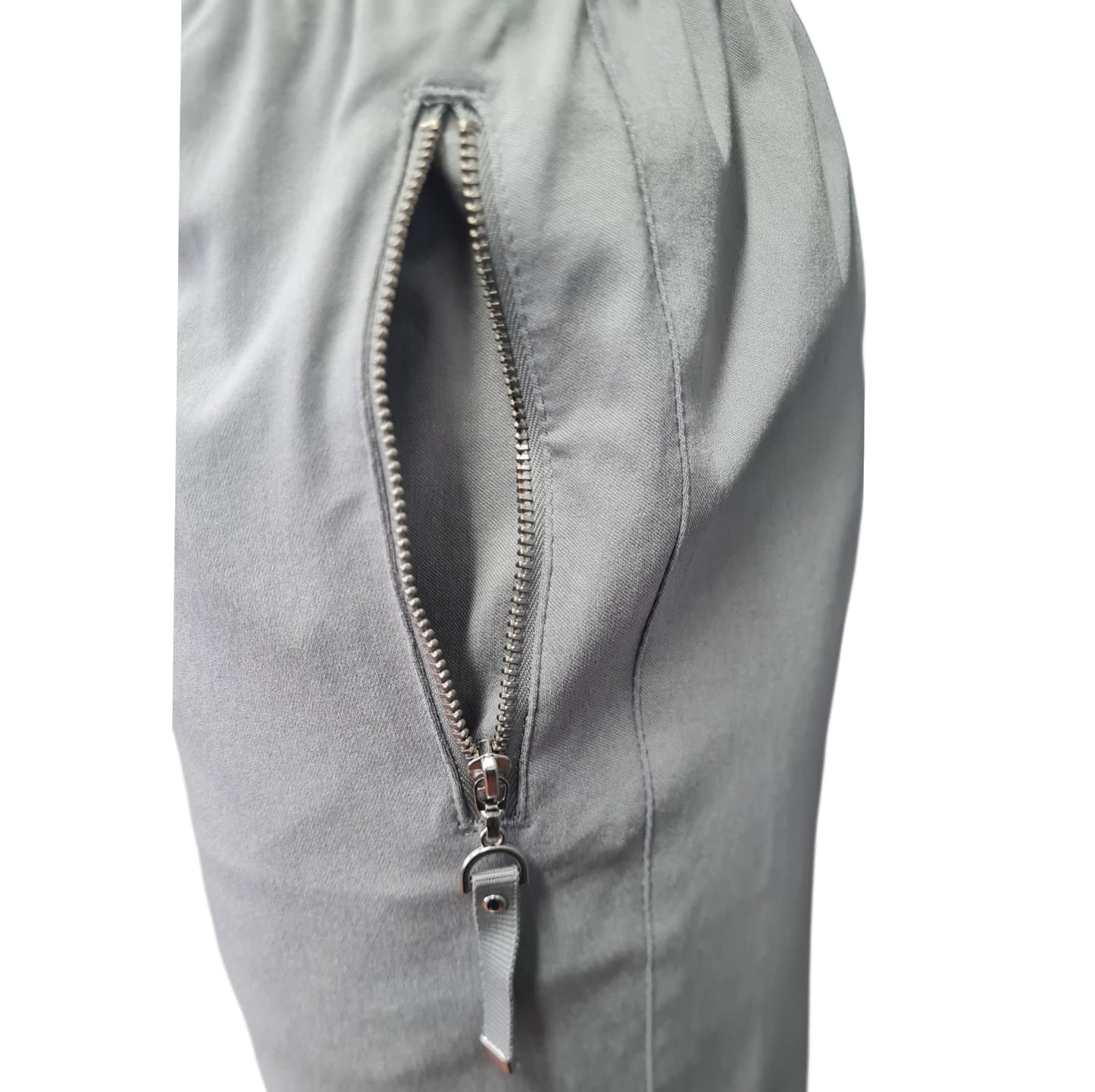 Unsere Hose Clarissa in Beige ist perfekt für Fitness und Freizeit. Hergestellt aus 70% Rayon, 26% Microfaser und 4% Elasthan, bietet sie ein kühles und atmungsaktives Material. Der breite Gummibund mit Kordel sorgt für einen bequemen Sitz, während die seitlichen Taschen mit Reißverschluss praktischen Stauraum bieten. Eine ideale Wahl für jedes Abenteuer! Ansicht Seitentaschen mit silbern Reißverschluss.