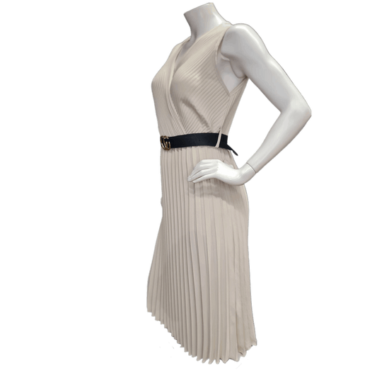 Farbe Beige und in schöner Plisierung. Mit schwarzen Gürtel und überschnittenen Schultern.