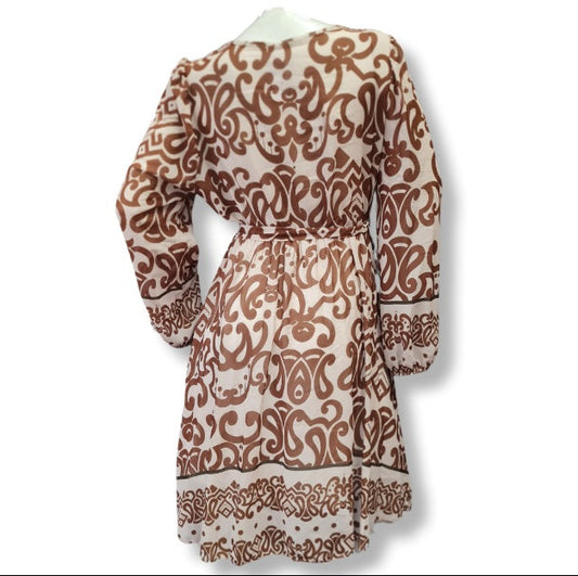 Ein Kleid mit langen Arm und aus leichten Viskose Stoff. Das Muster ist in großen Ornamenten und es hat eine Wickeloptik mit V-Ausschnitt und einen Gürtel aus dem gleichen Kleiderstoff gefertigt. Innenfutter deshalb Blickdicht.