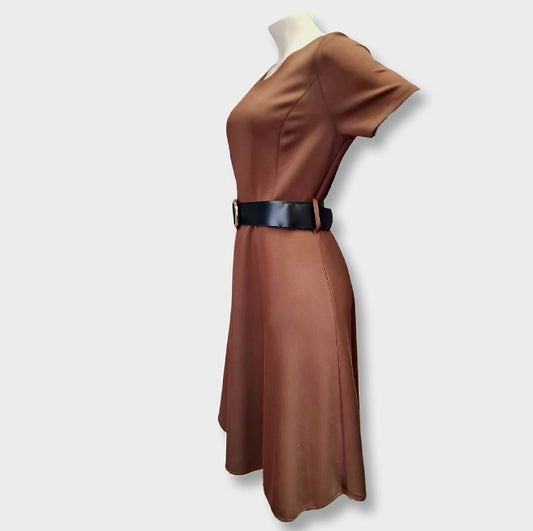 Ein Etuikleid mit schwarzen Gürtel und Rundhalsausschnitt. Perfekte Schnittführung.