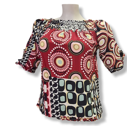 Eine Bluse mit Carmenausschnitt in den Farben Rosa, Rot mit halbarm und schlupe. Geomuster mit Kreisen