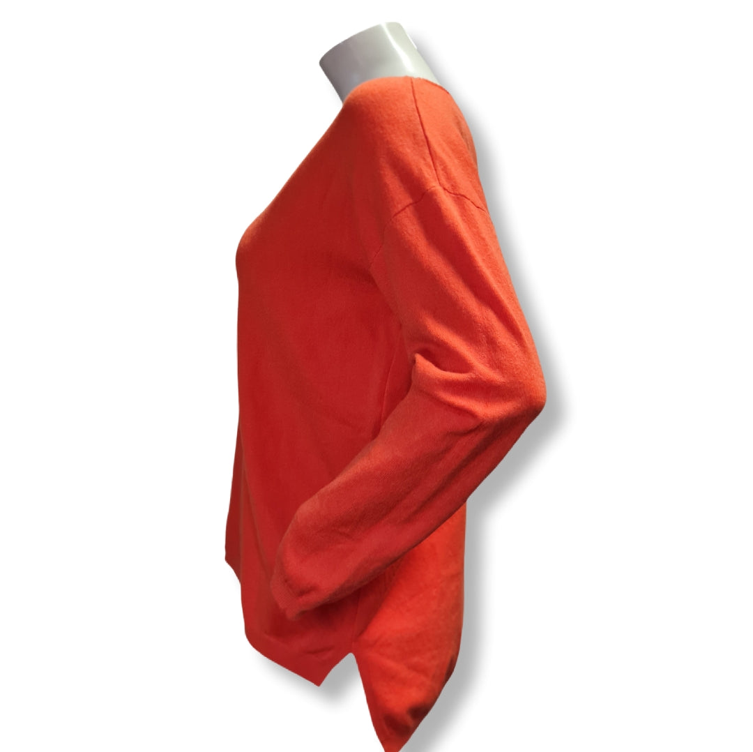 klassicher Feinstrickpulli in der Farbe Orange mit V-Ausschnitt uns seitlichen Schlitzen für mehr Bewegungsfreiheit. Hier die Seitenansicht. 