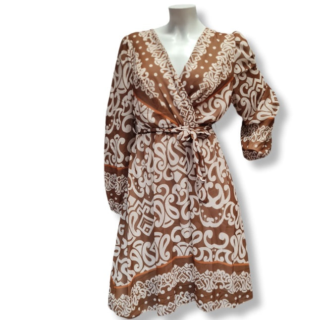 Ein Kleid mit langen Arm und aus leichten Viskose Stoff. Das Muster ist in großen Ornamenten und es hat eine Wickeloptik mit V-Ausschnitt und einen Gürtel aus dem gleichen Kleiderstoff gefertigt. Innenfutter deshalb Blickdicht. 