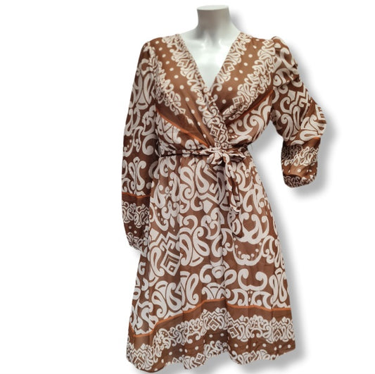 Ein Kleid mit langen Arm und aus leichten Viskose Stoff. Das Muster ist in großen Ornamenten und es hat eine Wickeloptik mit V-Ausschnitt und einen Gürtel aus dem gleichen Kleiderstoff gefertigt. Innenfutter deshalb Blickdicht. 