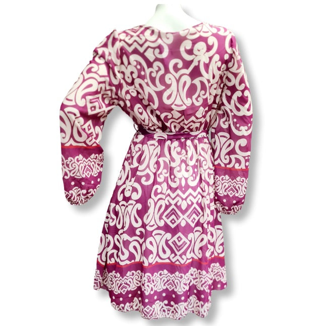 Alice in Beere ein kleid in Wickeloptik. Mit V-Ausschnitt und Gürtel. Der Alloverprintdruck ist in Ornamentenverzierung mit Bordürendruck. Lange Ärmel und Midlänge. 