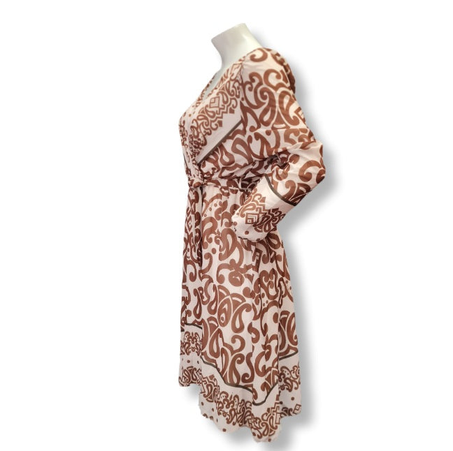 Ein Kleid mit langen Arm und aus leichten Viskose Stoff. Das Muster ist in großen Ornamenten und es hat eine Wickeloptik mit V-Ausschnitt und einen Gürtel aus dem gleichen Kleiderstoff gefertigt. Innenfutter deshalb Blickdicht. 