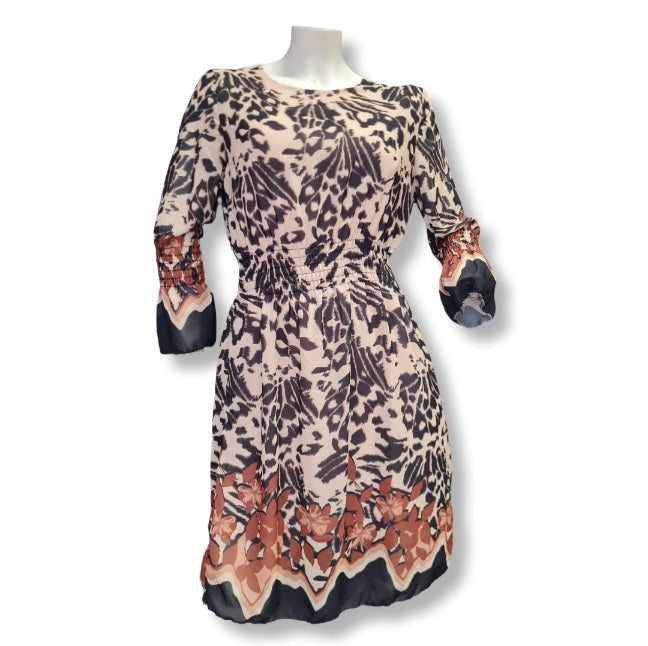 Ein Kleid mit beigen Untergrund darüber Druck in Animal mit Blumendruck. 