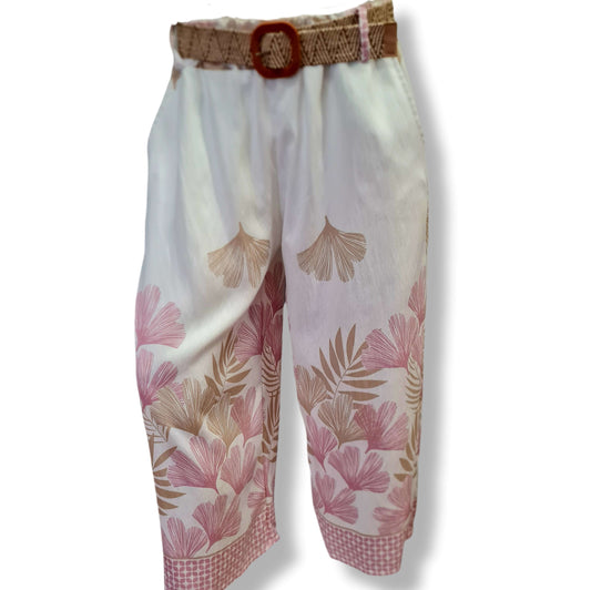 Palazoo Hose in Weiss mit großflächigen Druck auf beiden Beinen mit Motiv Ginkoblatt und Farn. In den Farben Beige und Rosé. Der obere Bereich ist Weiss. Mit Bastgürtel und Gummizug. 